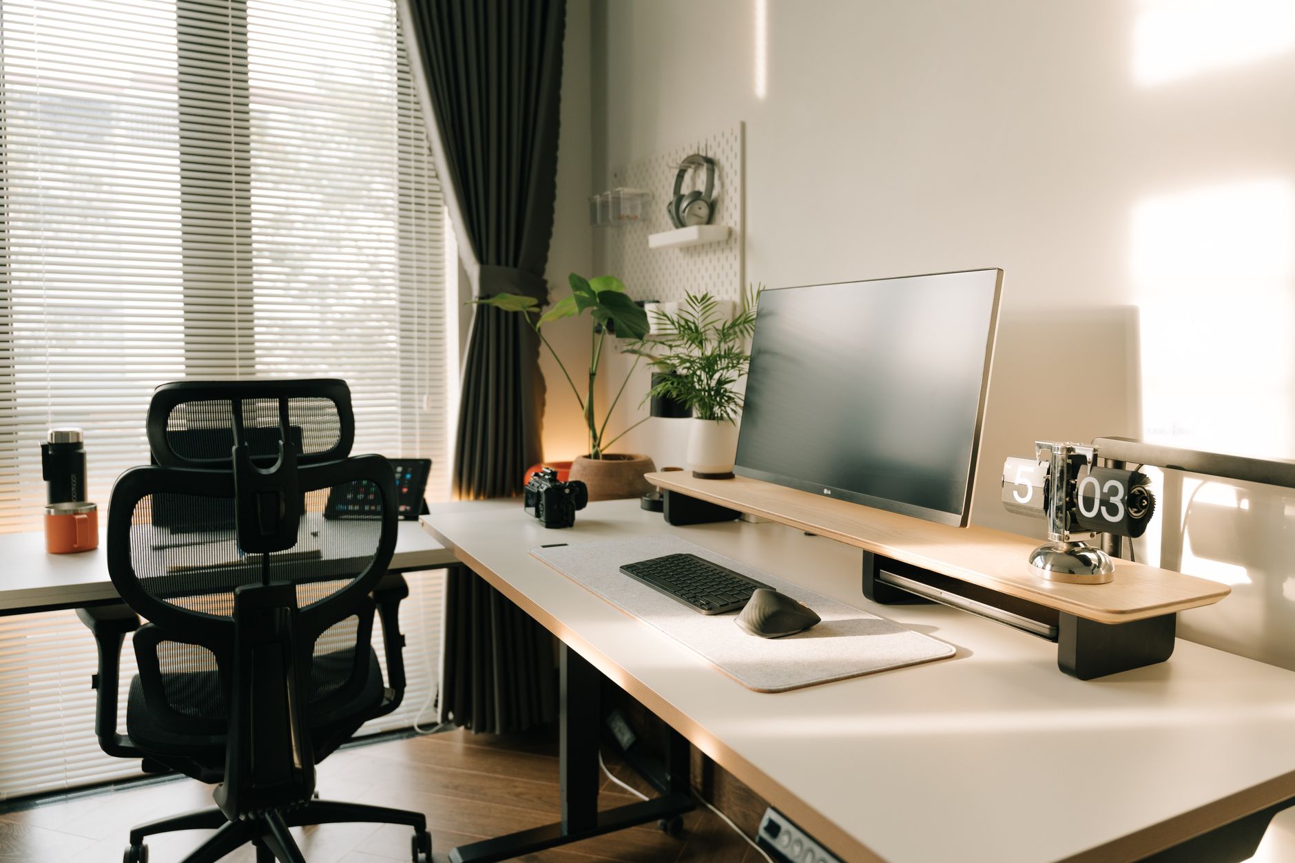 Poste de travail avec une chaise de bureau en résille, un écran surélevé et un clavier séparé