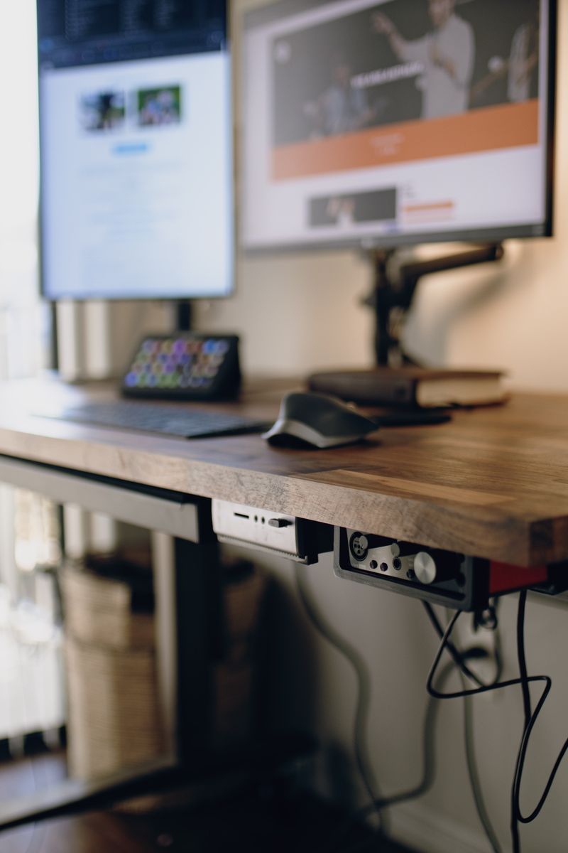 Bureau en bois équipé de deux écrans, d’un clavier et d’une souris
