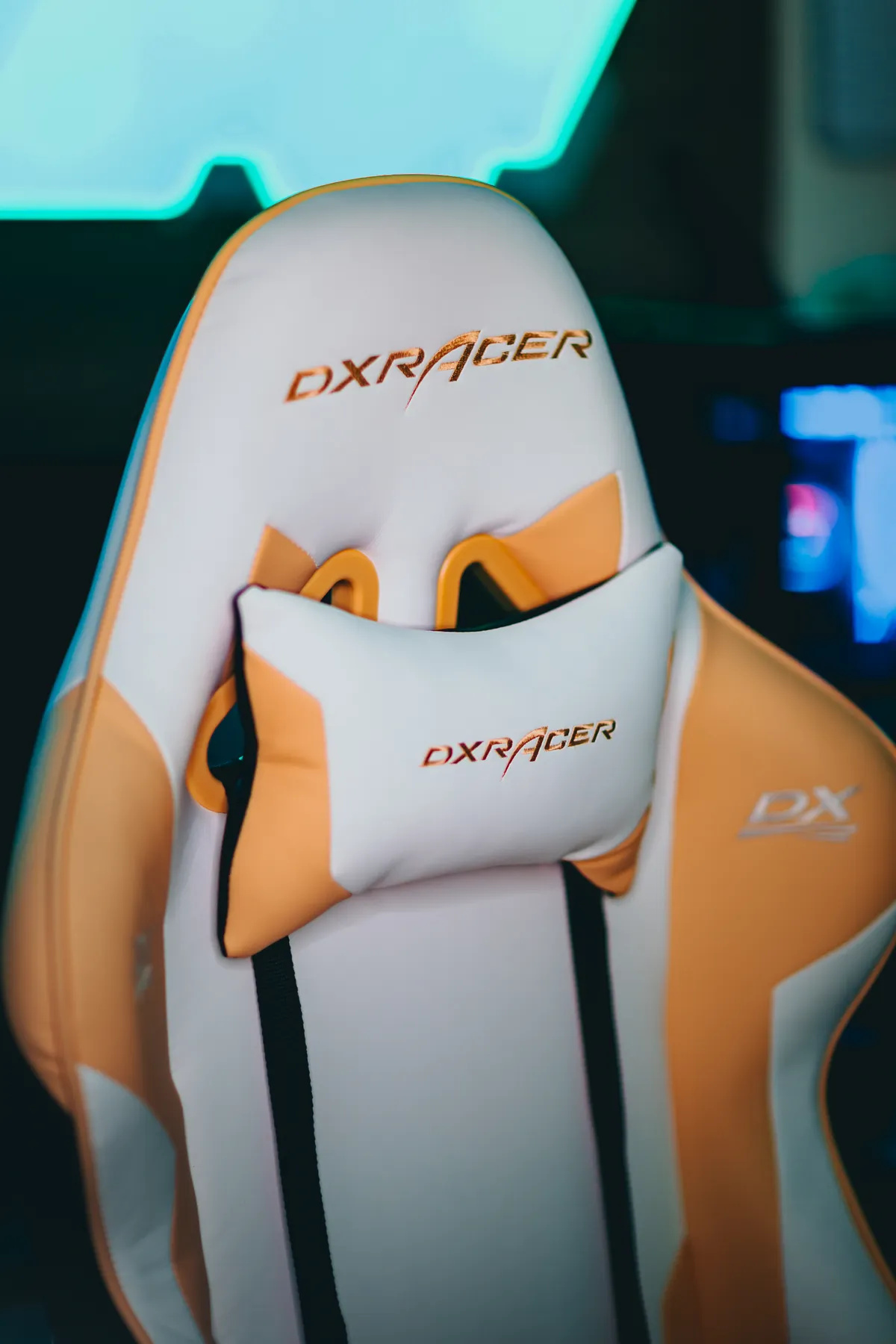 Dossier haut d’un fauteuil gaming DXRacer blanc et orange avec coussin de nuque