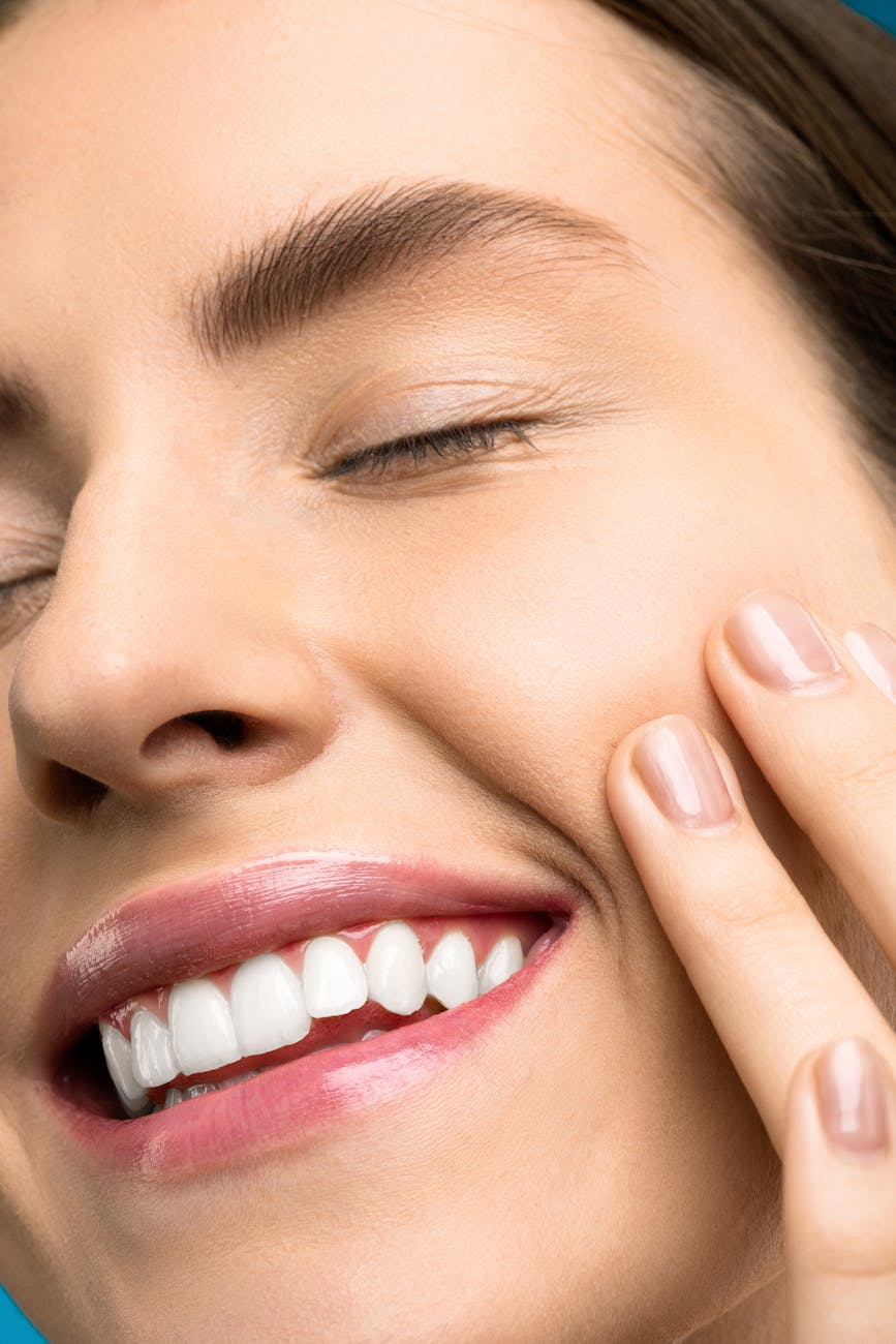 photo en gros plan de femme avec rouge a levres rose souriant avec ses yeux fermes