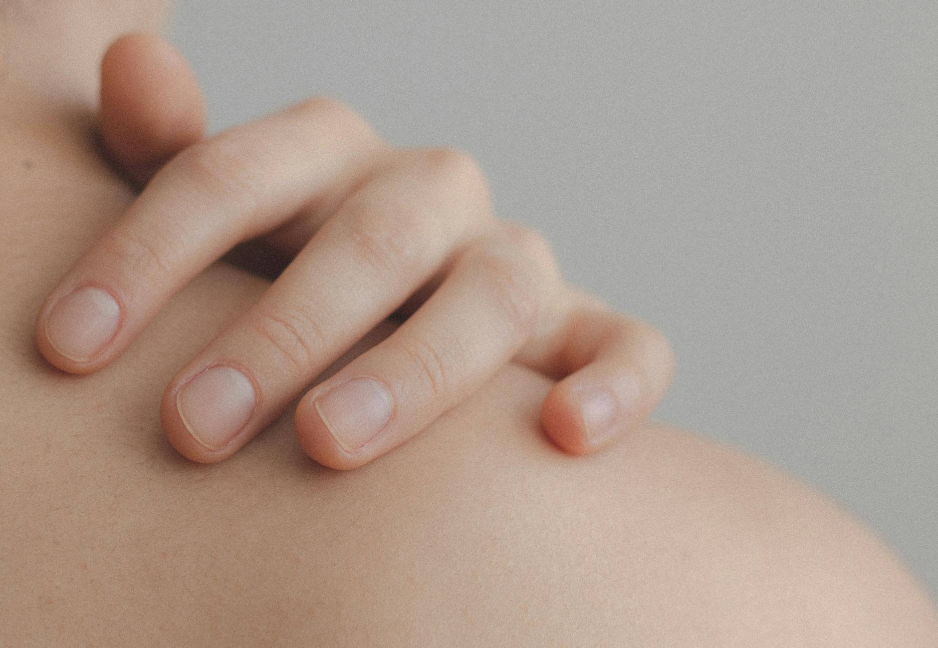 photo en gros plan d une personne touchant son epaule