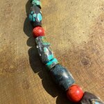 Gros plan sur les pierres turquoise et gorgone rouge