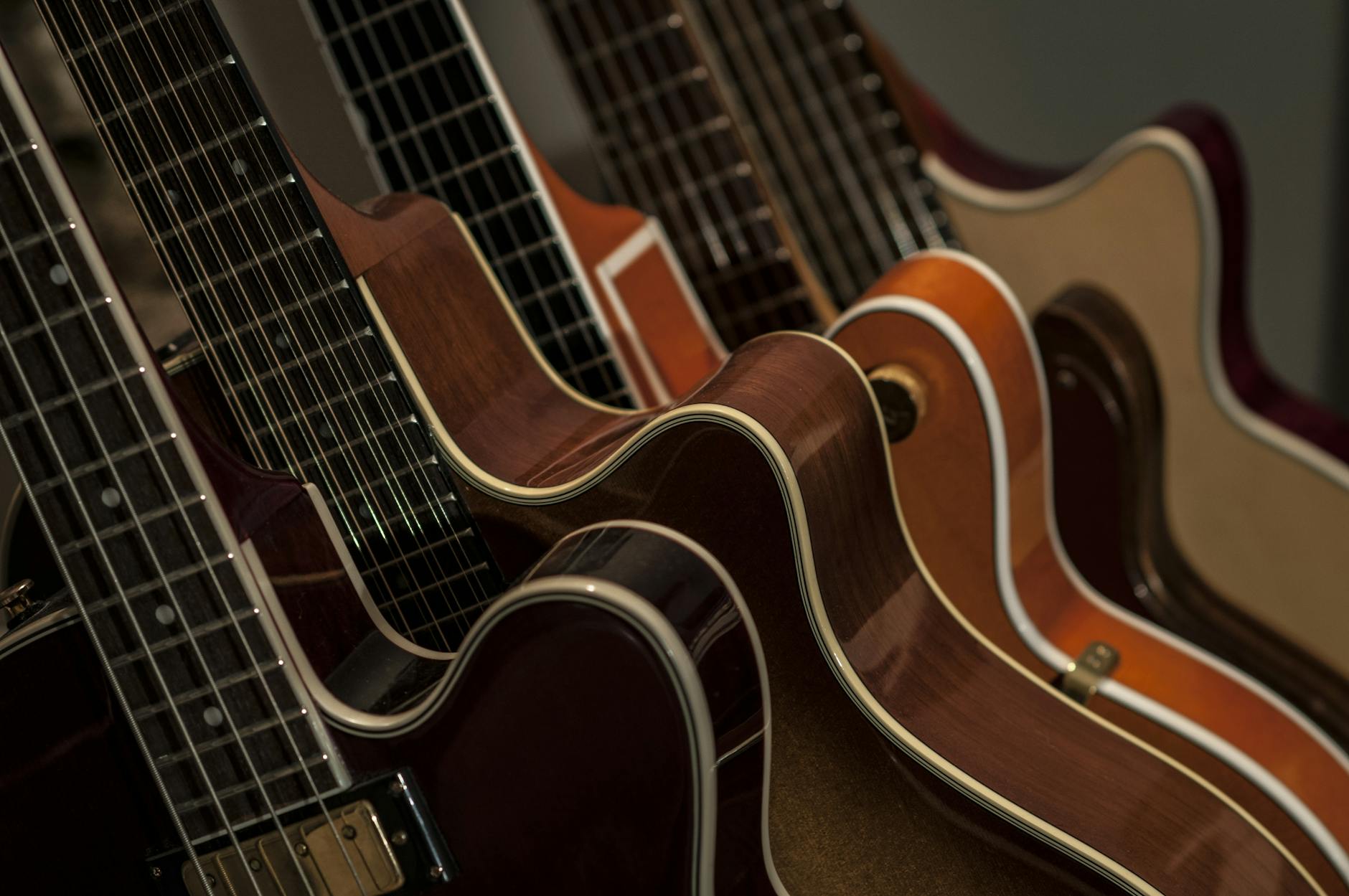 detailed shot of diverse acoustic guitars lined up showcasing strings and wood texture