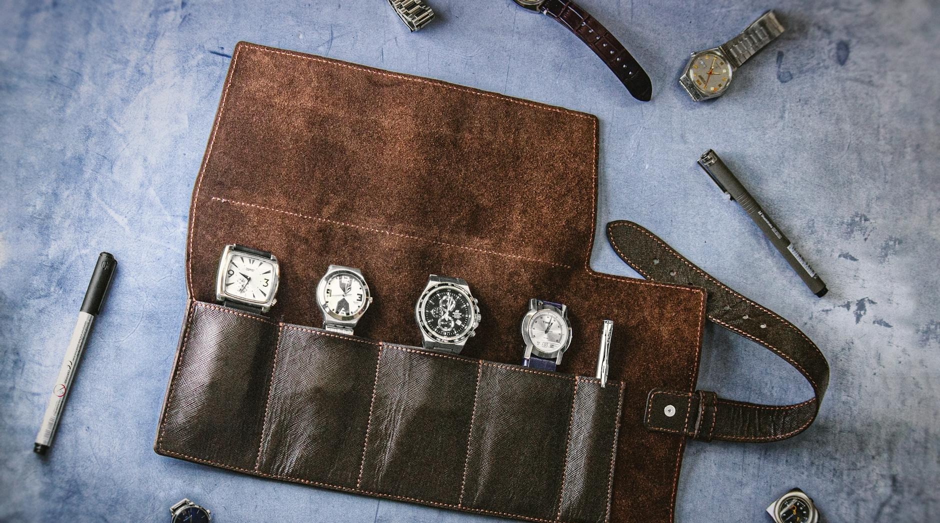 a collection of vintage watches in a handmade leather roll case perfect for travel