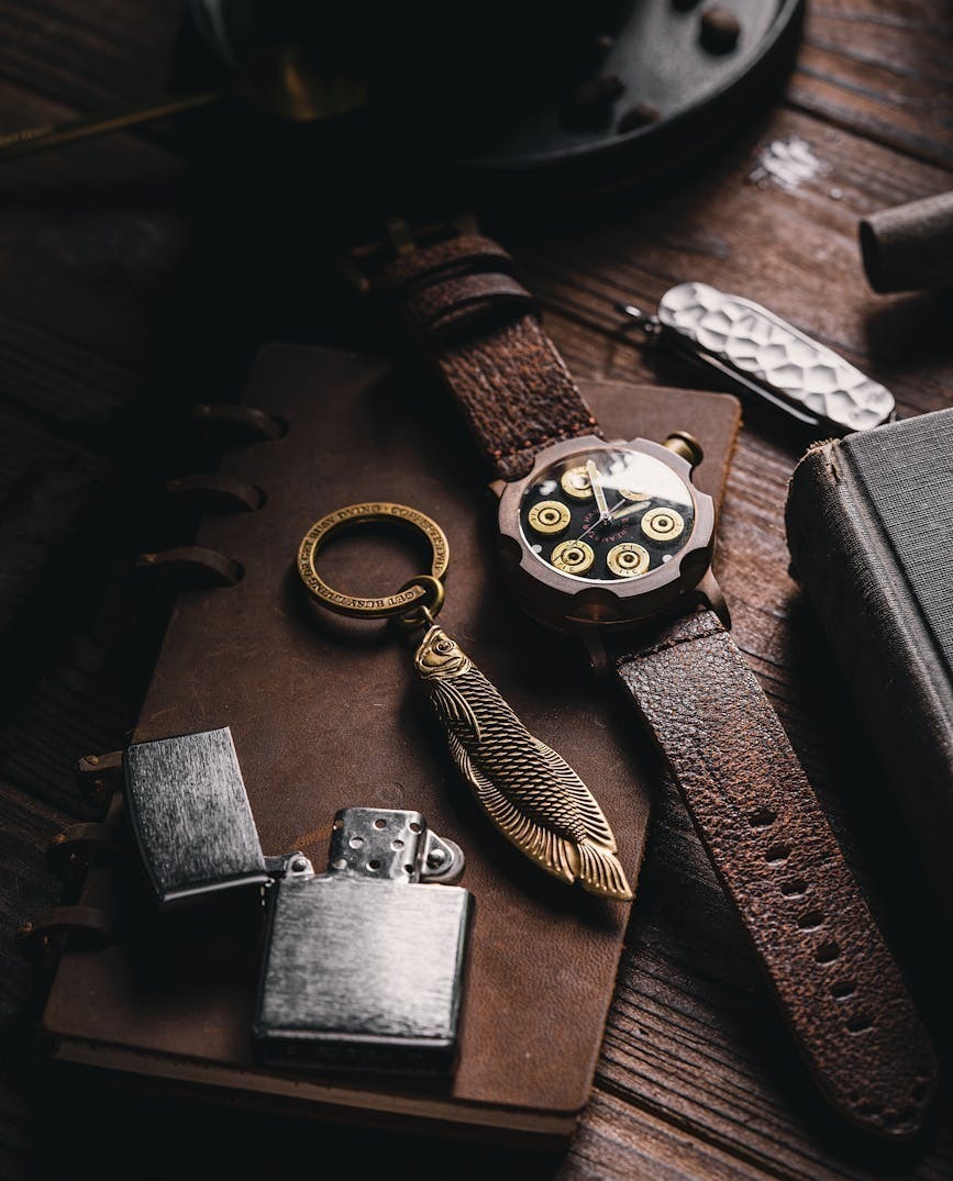 a stylish flat lay of vintage leather journal wristwatch and accessories on wooden table