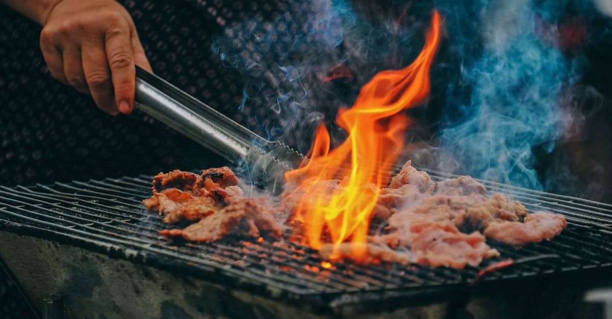 close up of grilling meat with vibrant flames and smoky aura showcasing outdoor cooking