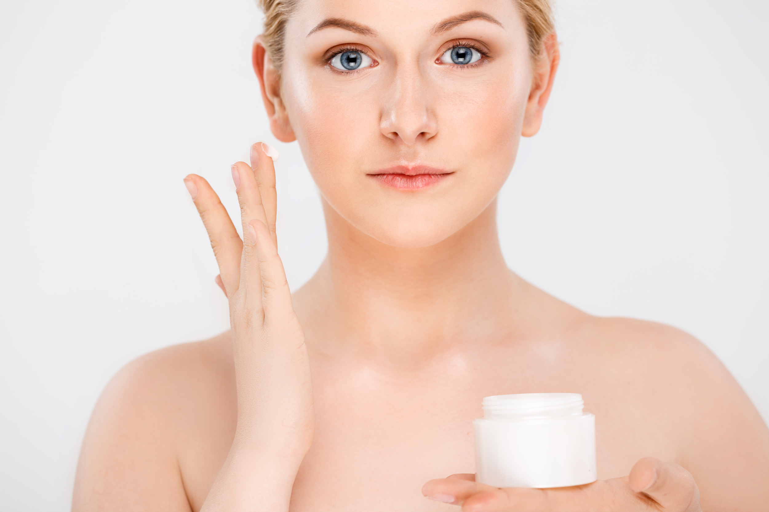 beautiful smiling woman apply facial cream