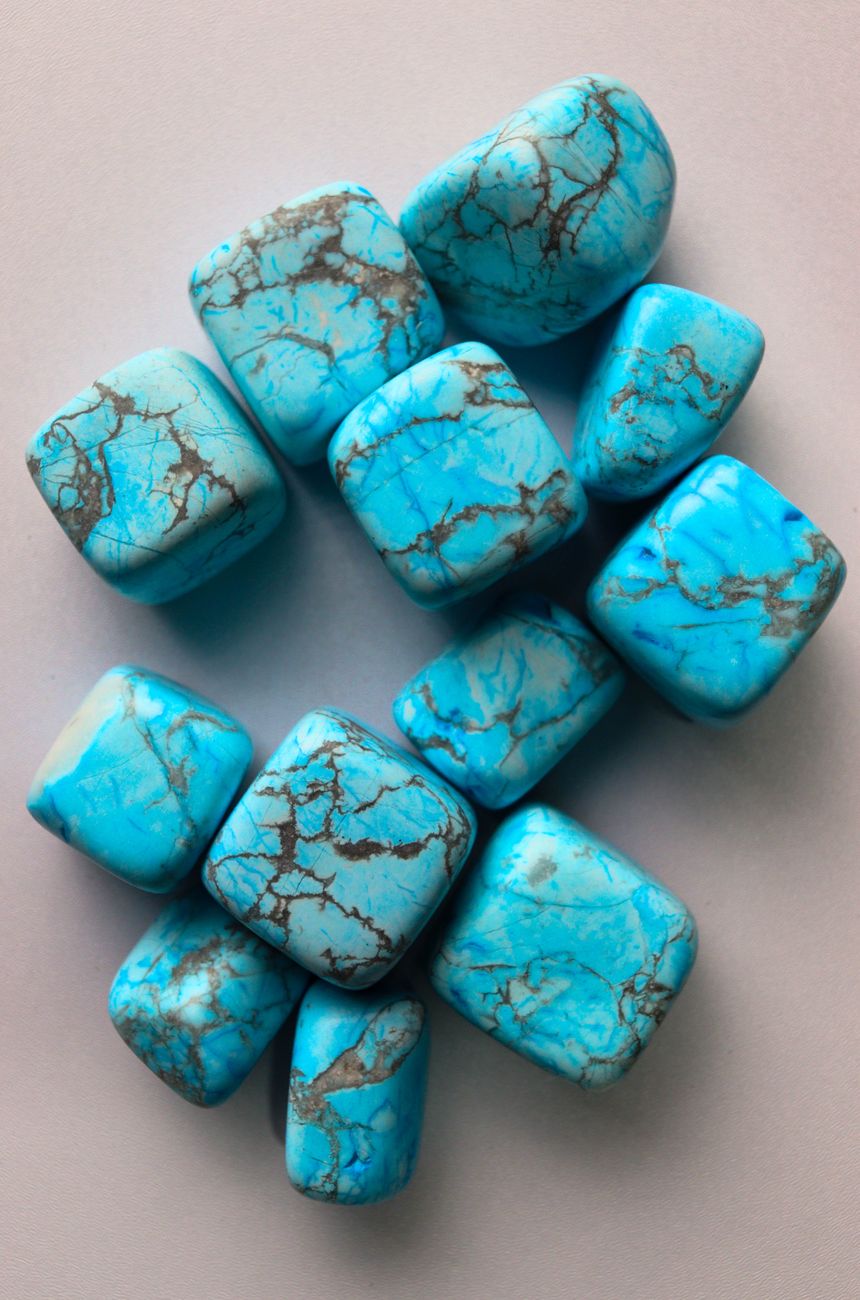 une collection de pierres turquoises polies presentees en plan avec un fond neutre