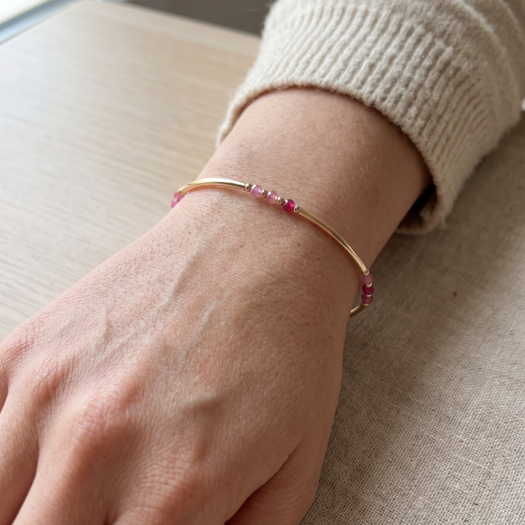 Bracelet jonc louxor en pierres precieuses, rubis et goldfilled porté au poignet