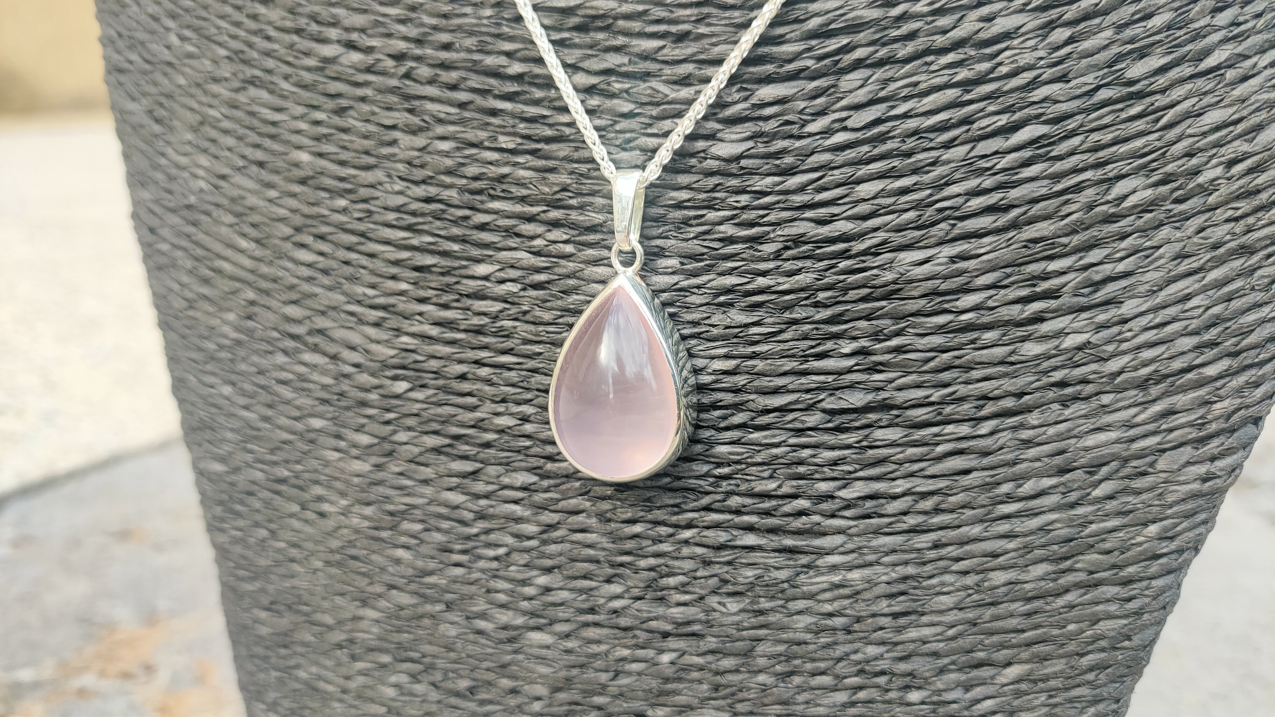 Sertissage manuel d'un cabochon en quartz rose par l'artisan bijoutier de la Bijouterie JK