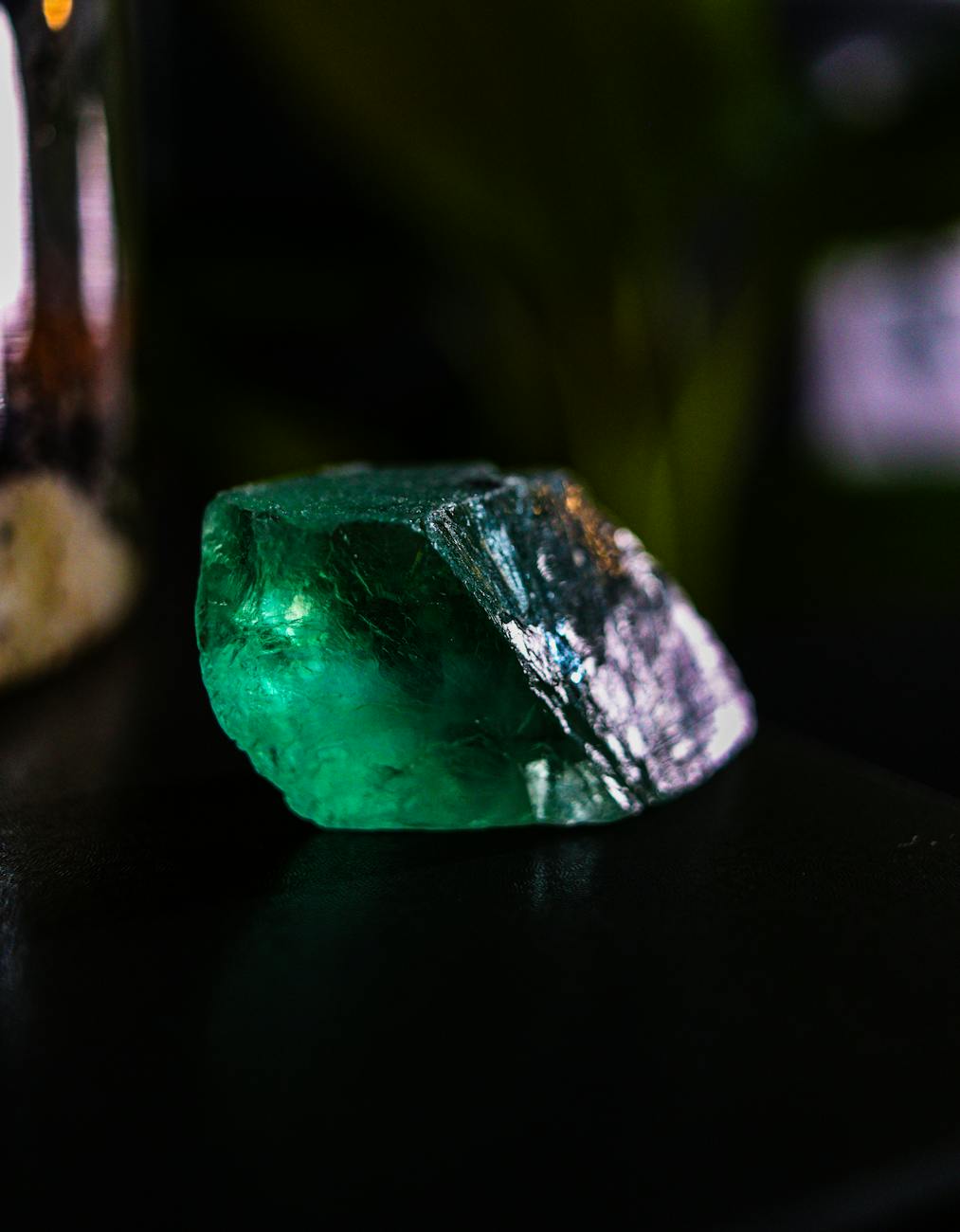 Émeraude verte brute sur fond sombre, pierre précieuse d'exception pour joaillerie artisanale