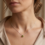 Femme portant un collier fin en argent 925 avec un pendentif solitaire en pierre verte - Création Bijouterie JK