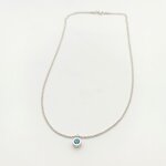 Photographie de produit professionnelle d'un collier pendentif en argent 925 avec topaze bleue ronde en serti clos sur fond blanc. Chaîne maille vénitienne de 41 cm. Élégance minimaliste