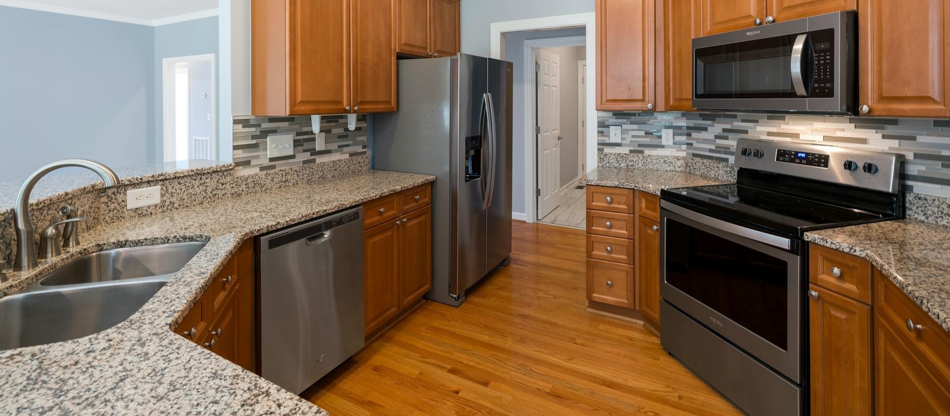 spacious kitchen interior featuring granite countertops stainless steel appliances and wooden cabinets