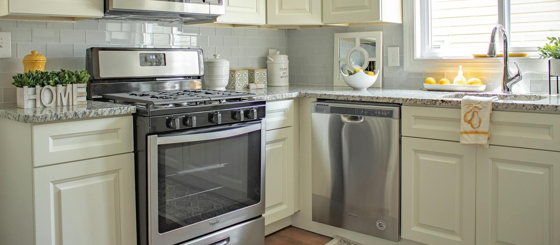 bright kitchen featuring white cabinetry and stainless steel appliances with a cozy design