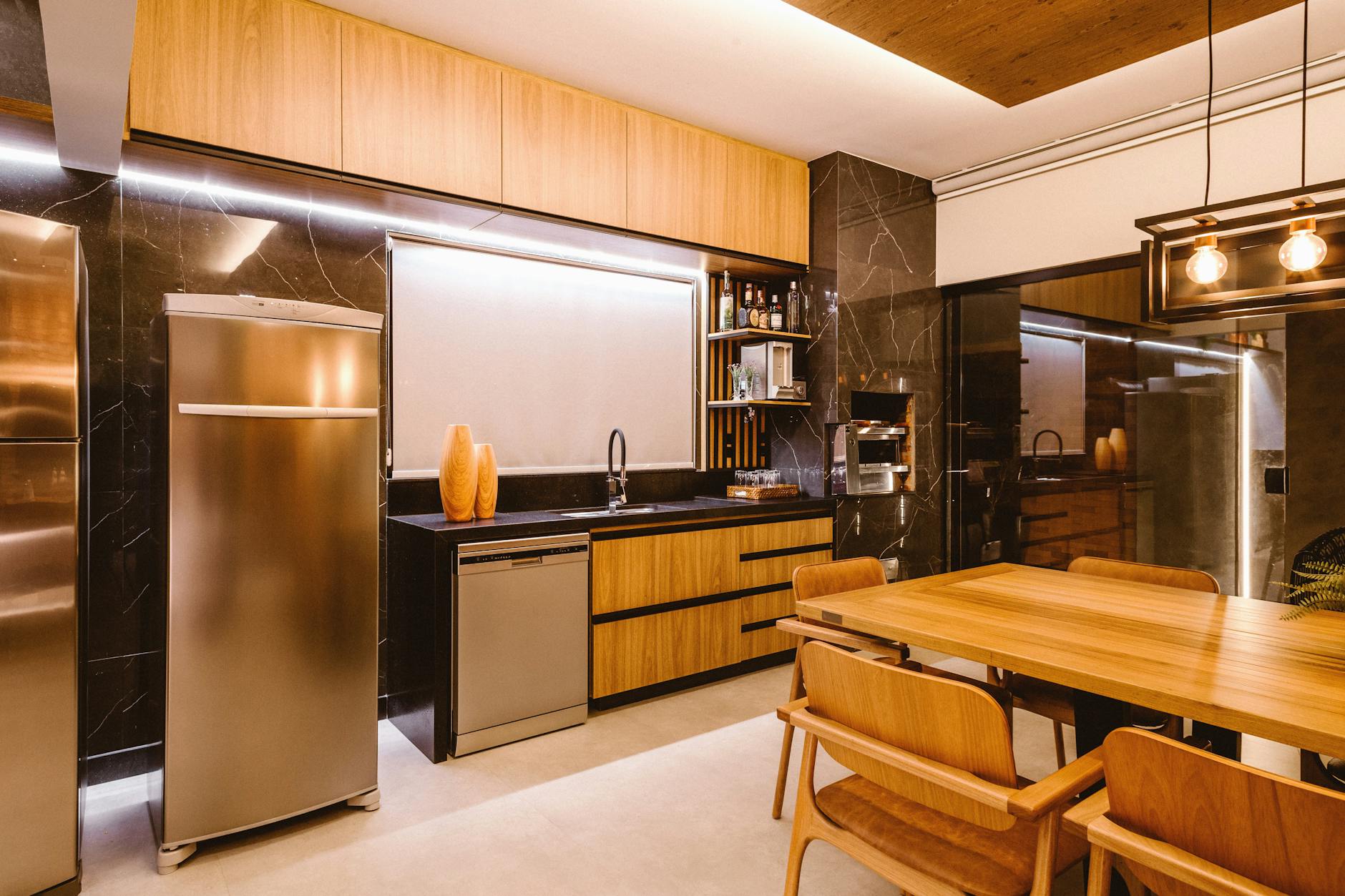 stylish kitchen with wooden furniture stainless appliances and a modern pendant light