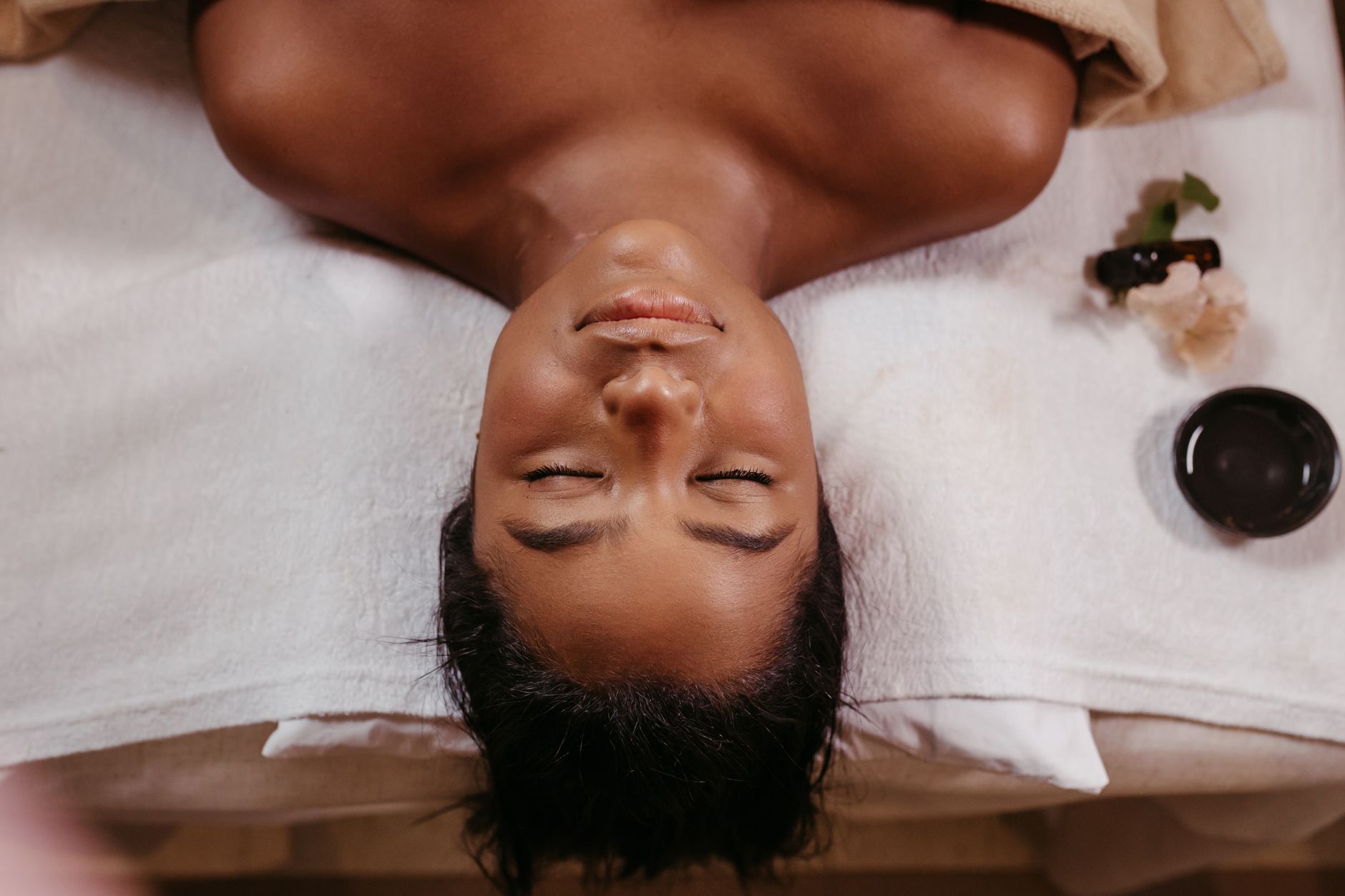 une femme profitant d un traitement de spa paisible allongee torse nu les yeux fermes sur une serviette blanche