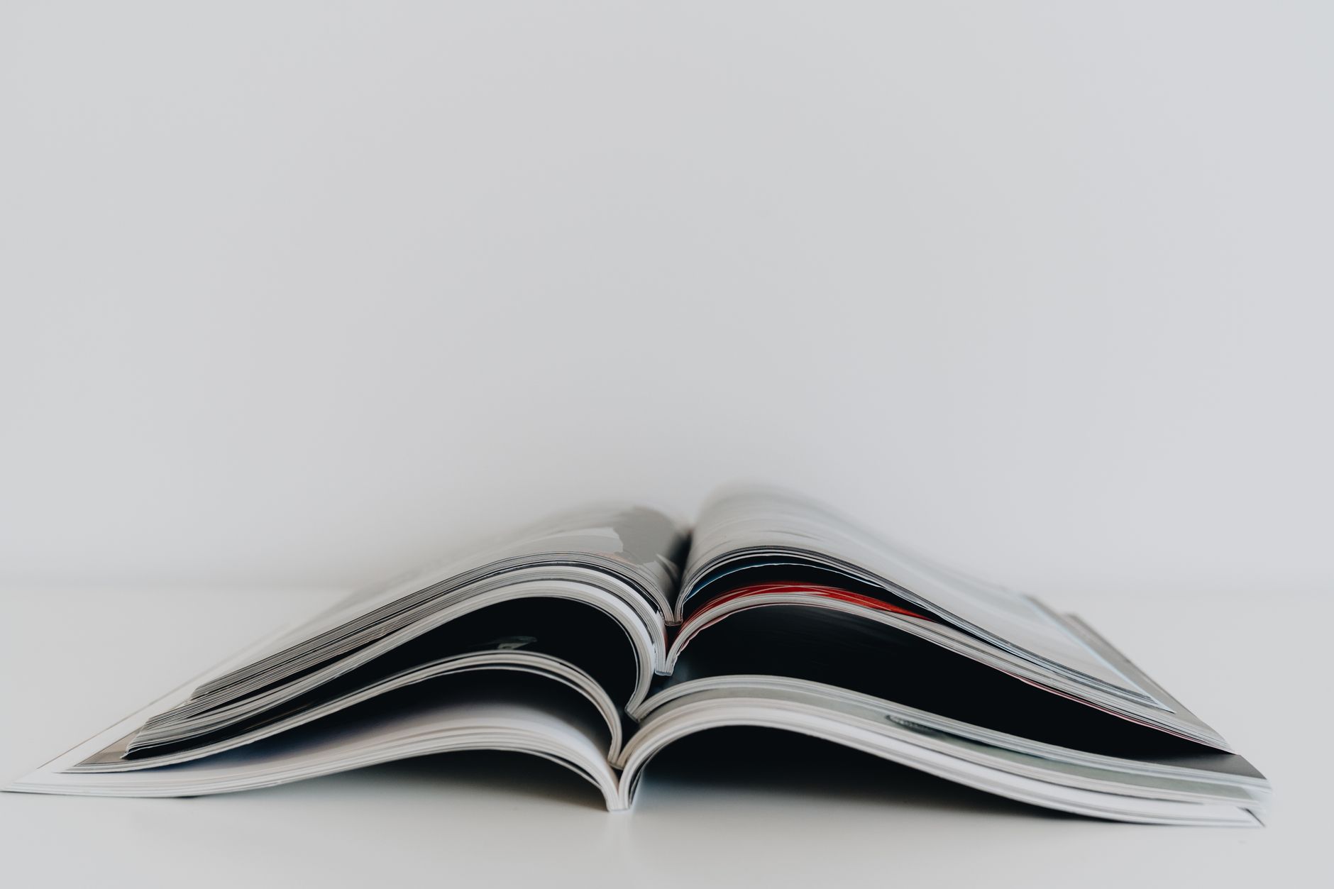 image minimaliste d un magazine ouvert sur une table blanche ideale pour des sujets litteraires