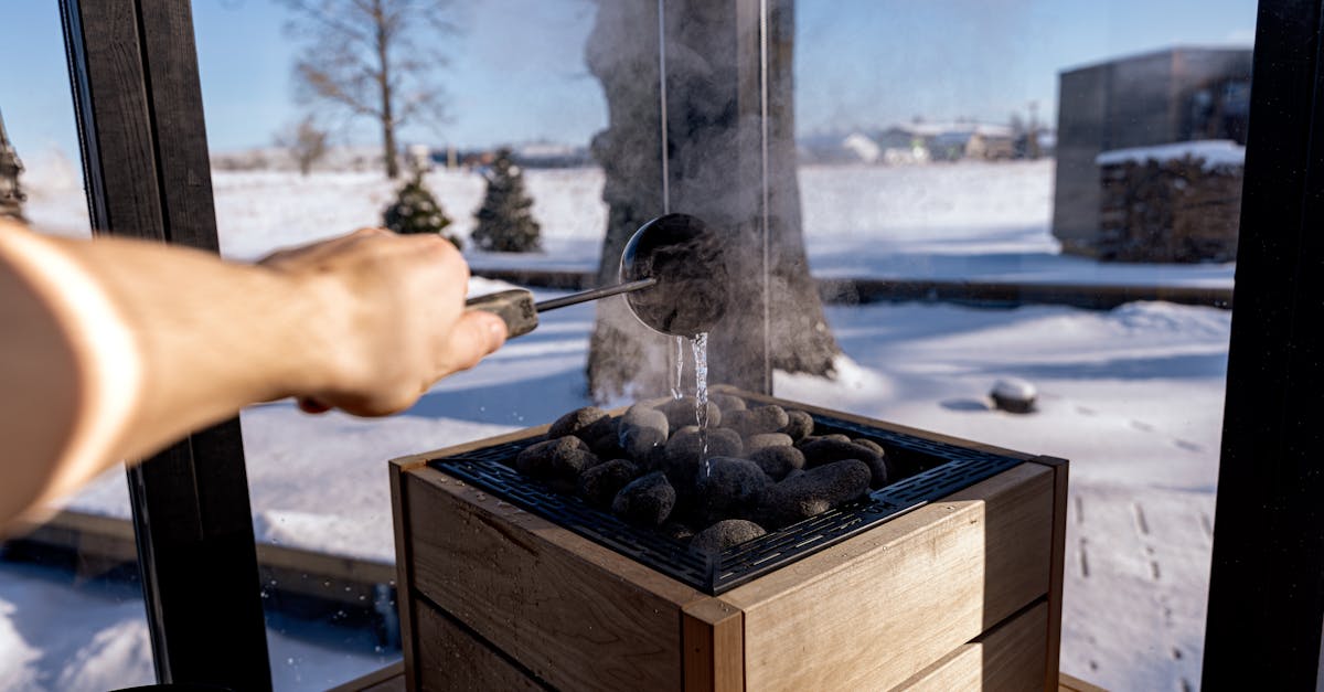 steam rises from sauna stones as water is poured in a snowy nordic setting capturing a serene and warming experience