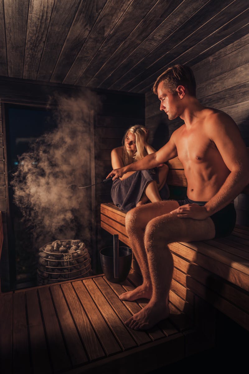 a couple enjoying a relaxing time in a warmly lit nordic sauna