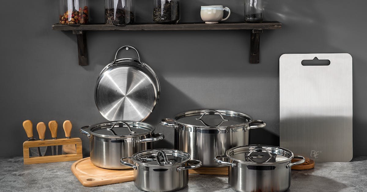 stylish kitchen setup featuring stainless steel pots and kitchen accessories on a gray background