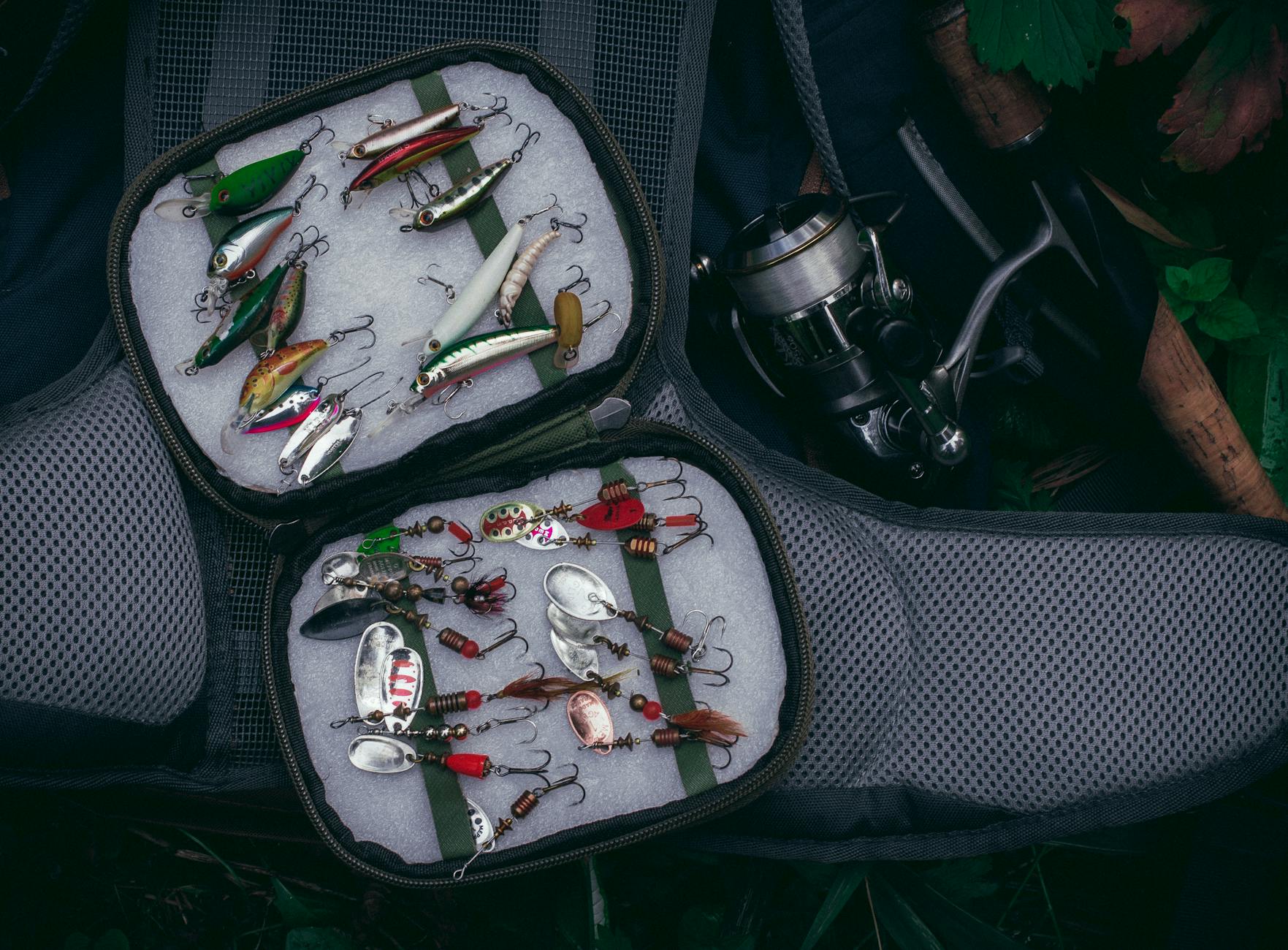 top view of a well organized fishing kit featuring colorful lures and a fishing reel
