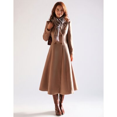Woman wearing a long camel double-breasted wool coat with a gray scarf
