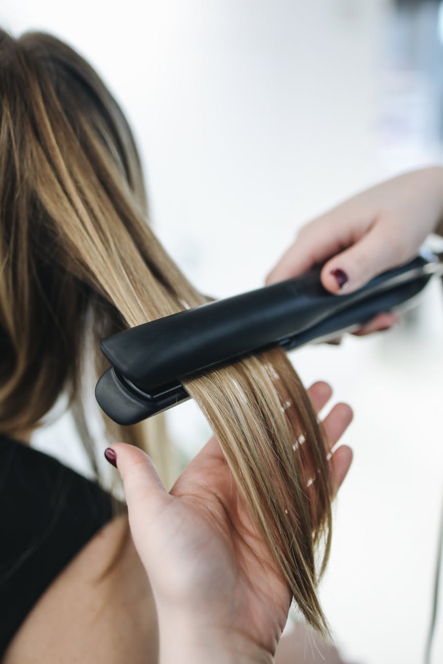 personne repassant les cheveux d une femme