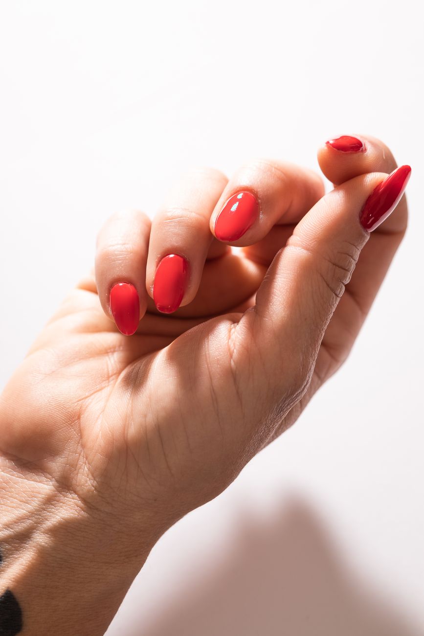 gros plan sur la main d une femme avec une manucure rouge elegante posee contre un fond clair