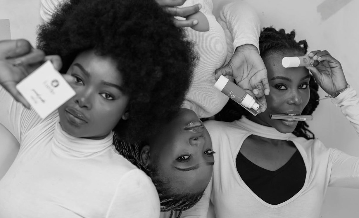 portrait en noir et blanc de trois femmes tenant des produits de soin et de beaute dans une pose gracieuse