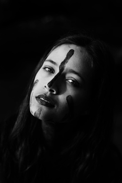 Femme Malheureuse Avec Le Visage Peint Sur Fond Noir