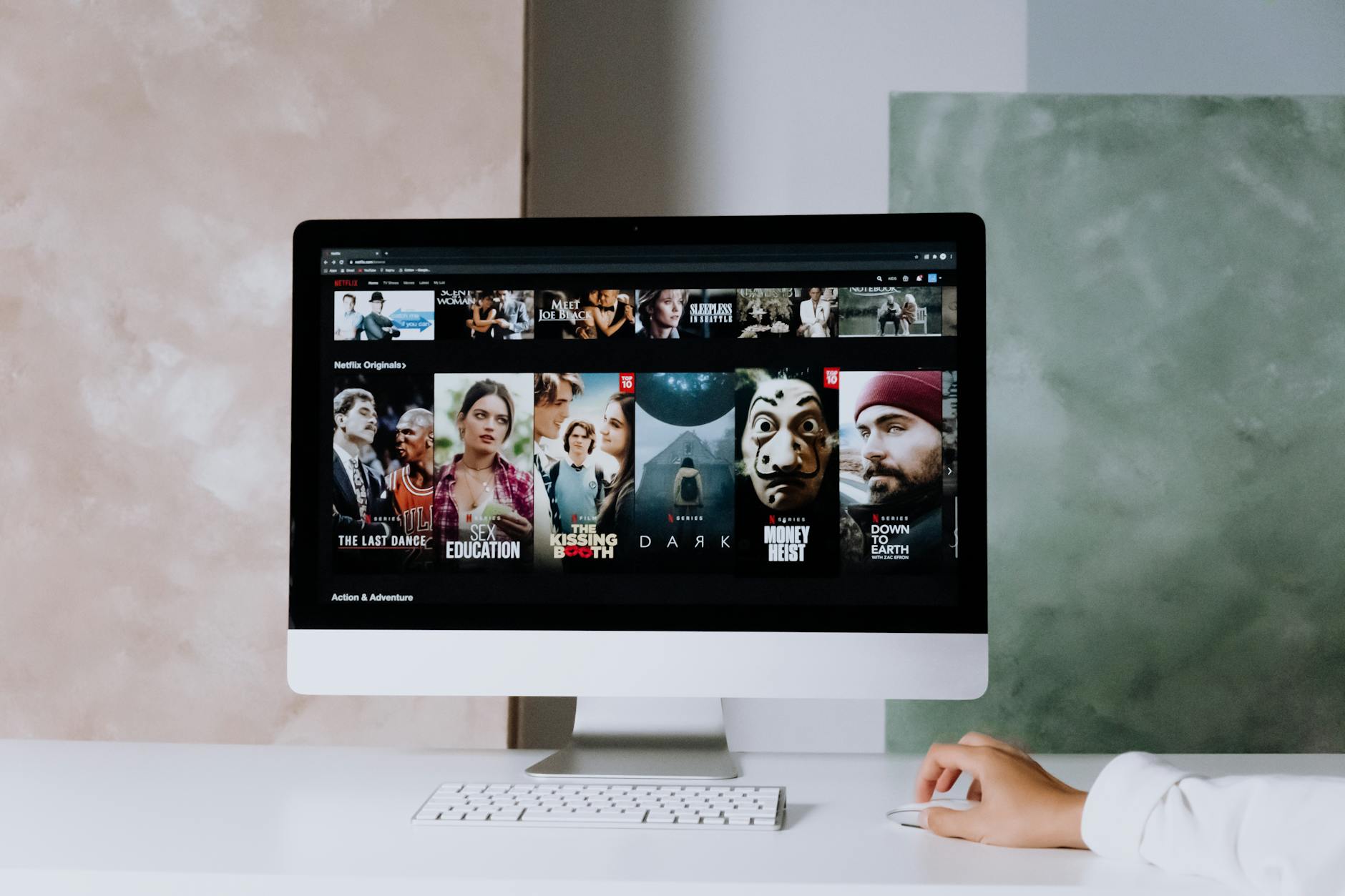 a modern workspace featuring a desktop screen displaying popular streaming series on netflix