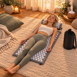 Femme détendue allongée sur un tapis dacupression gris