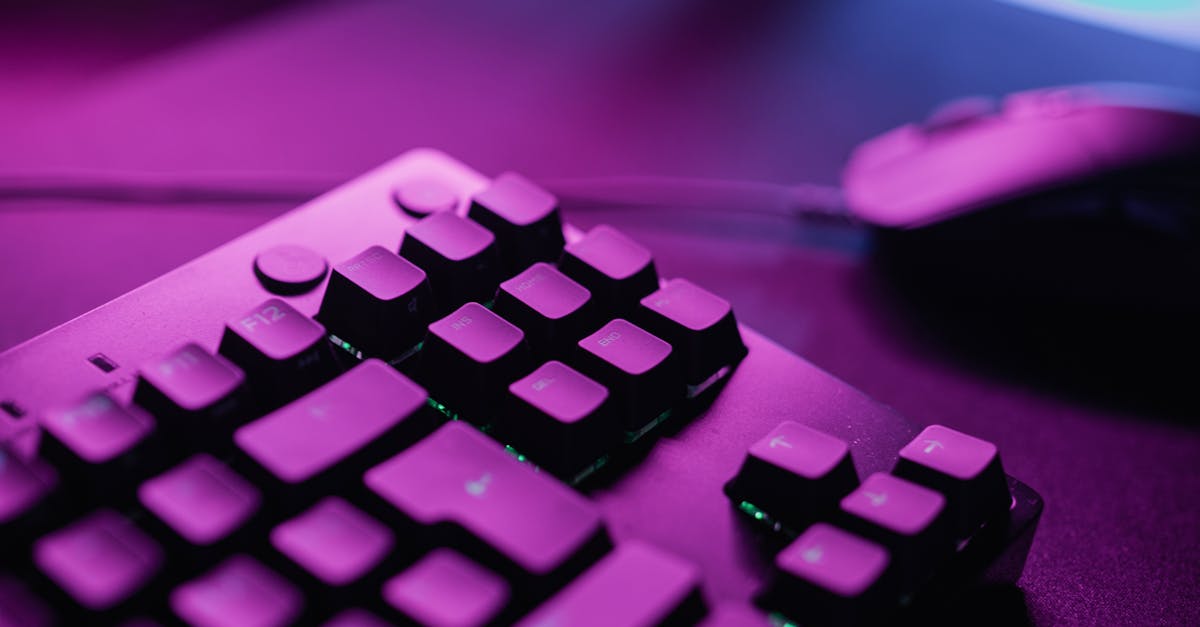 close up of a gaming keyboard and mouse illuminated by vibrant pink lighting creating a dynamic atmosphere