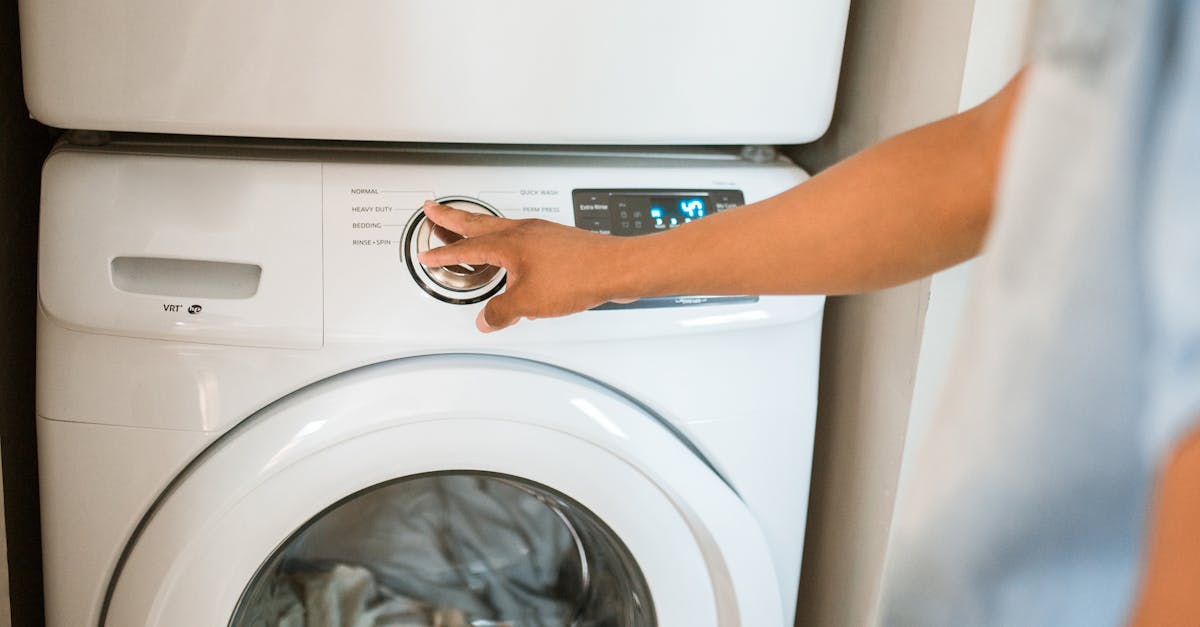 close up of a person adjusting a washing machine in a modern laundry room