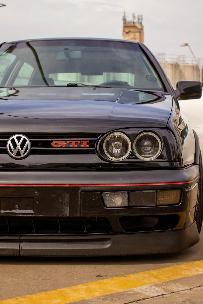 front view of a black volkswagen gti parked in an urban setting with visible yellow lines