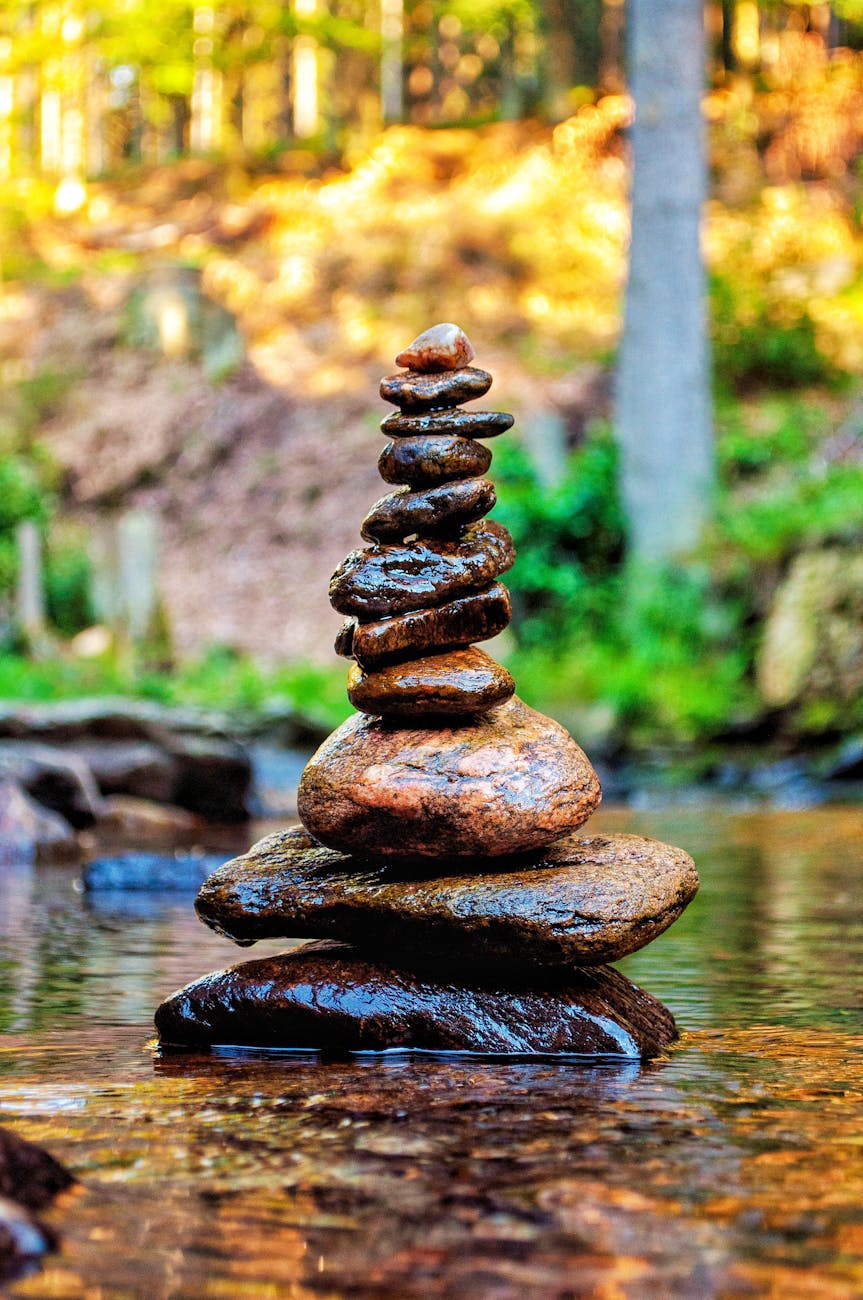 meditative stone stack in serene forest stream embodying nature and tranquility