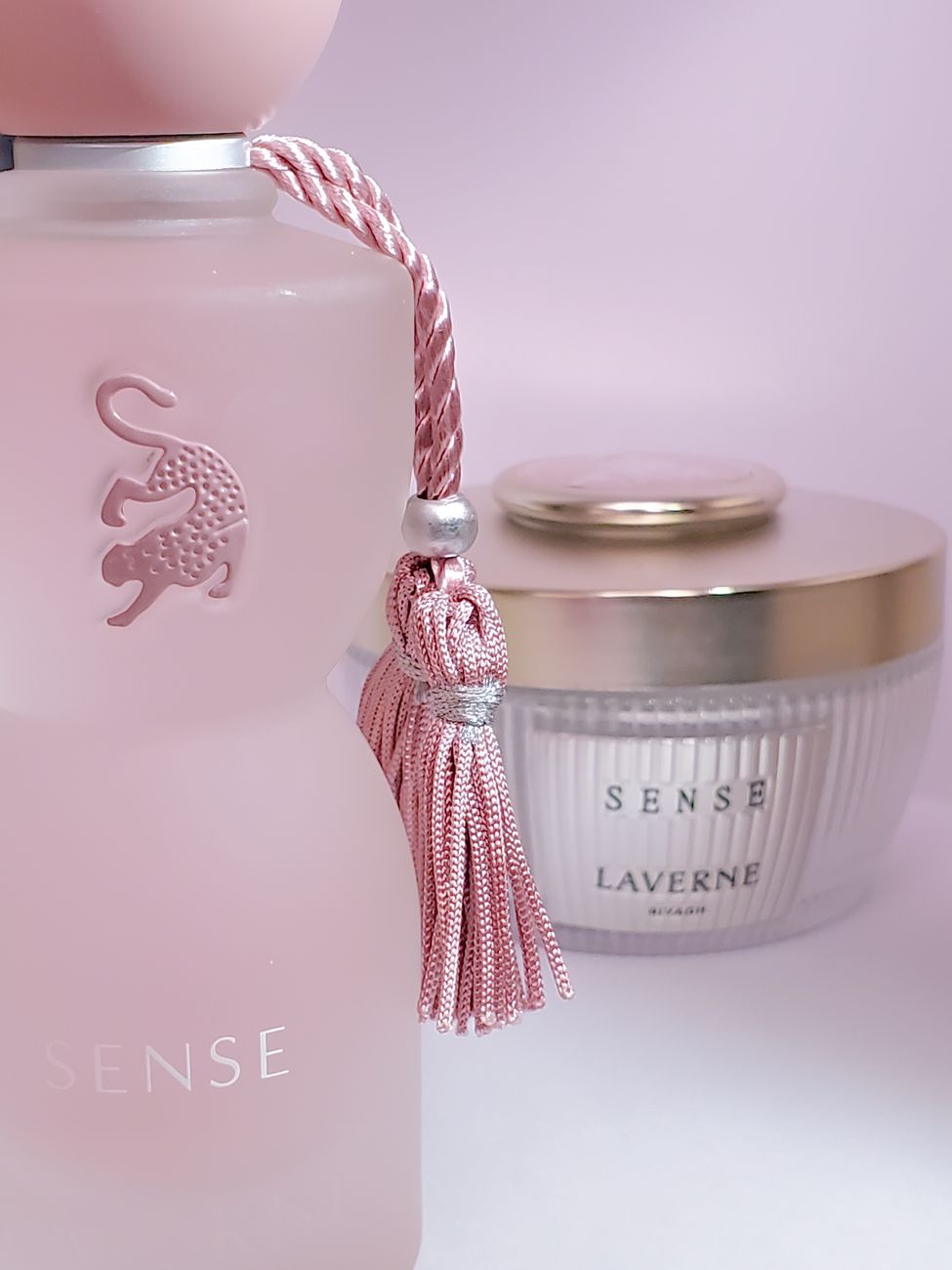 agencement style d une bouteille de parfum rose et d une bougie parfumee sous un eclairage doux