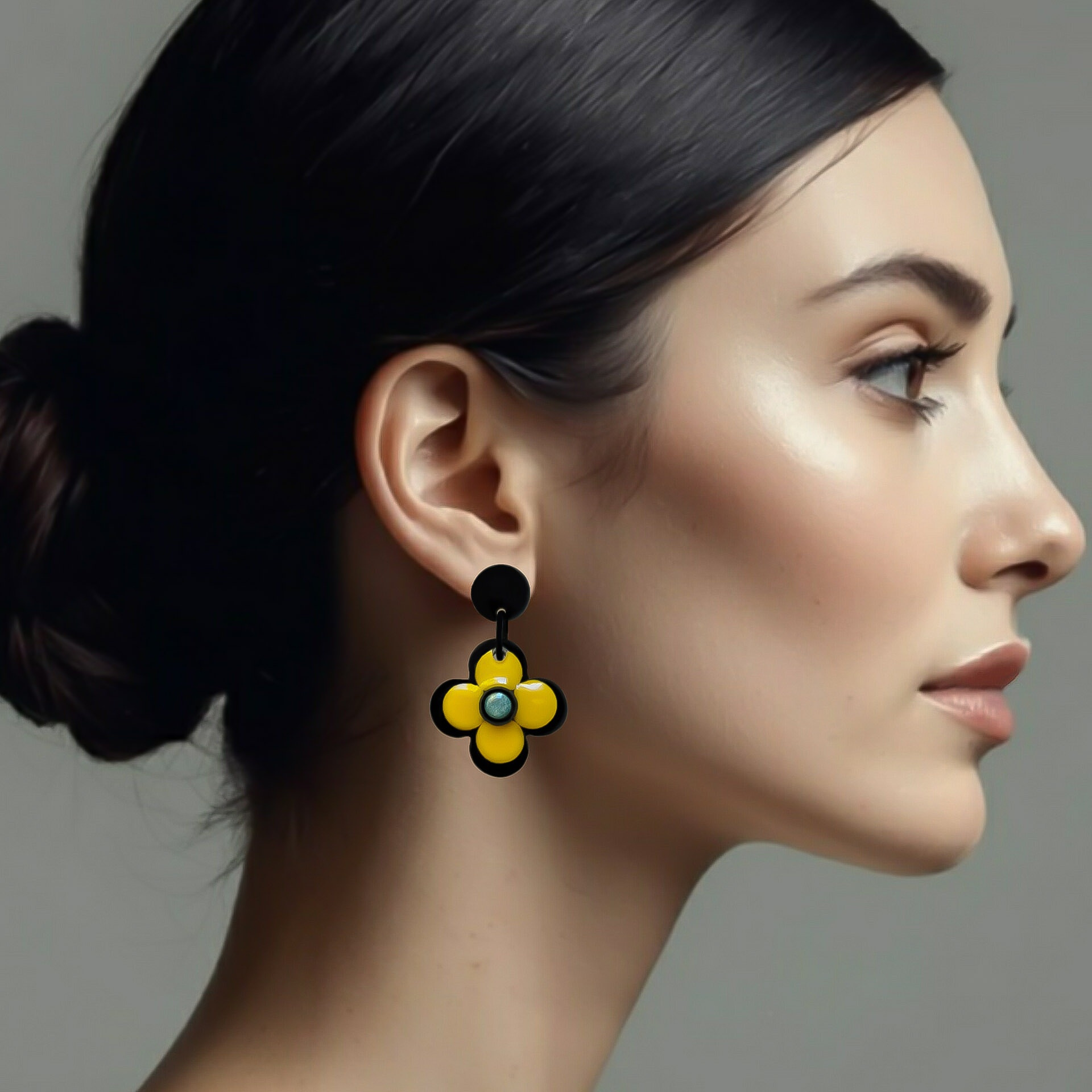 Petite boucle d'oreilles fleur jaune et noire sur mannequin vu de profil