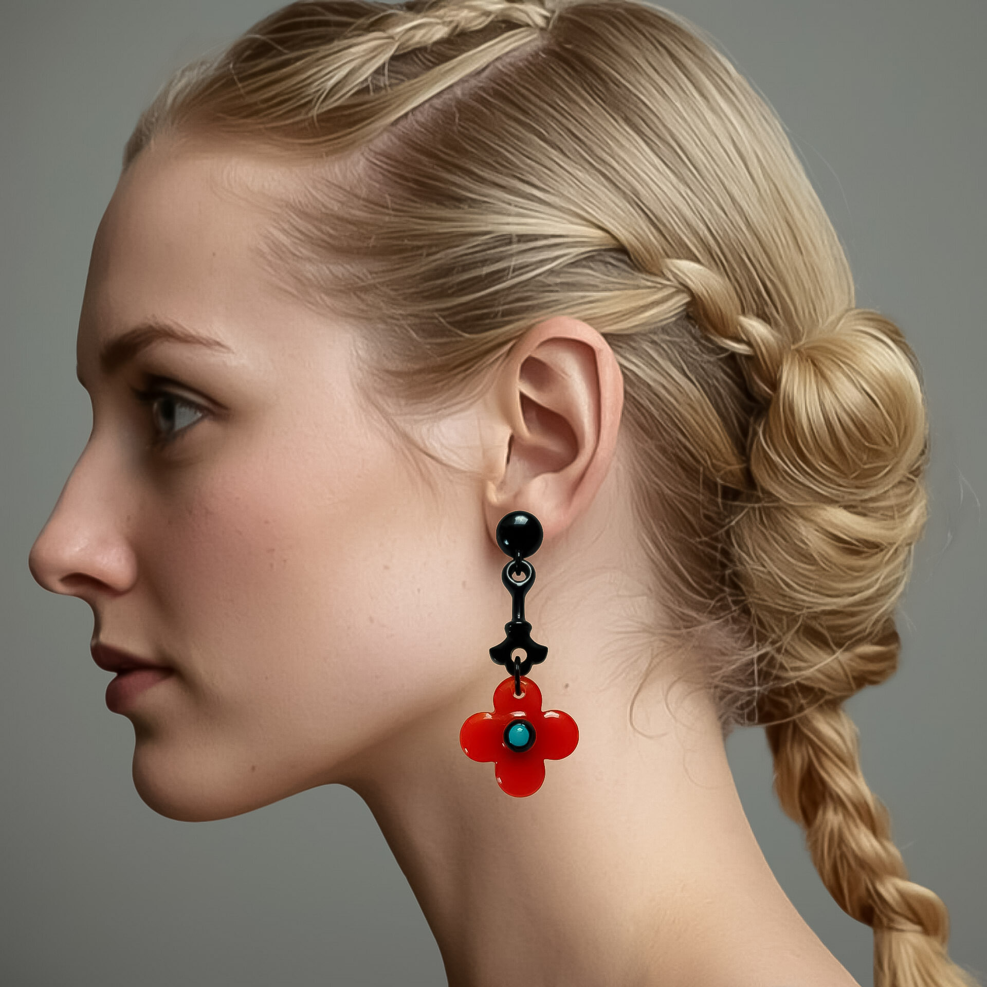 Boucle d'oreilles pendante de taille moyenne à fleur orange et tige noire sur visage de femme vu de profil