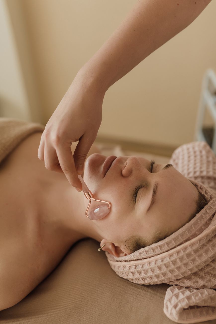 une personne utilise un rouleau facial sur une femme
