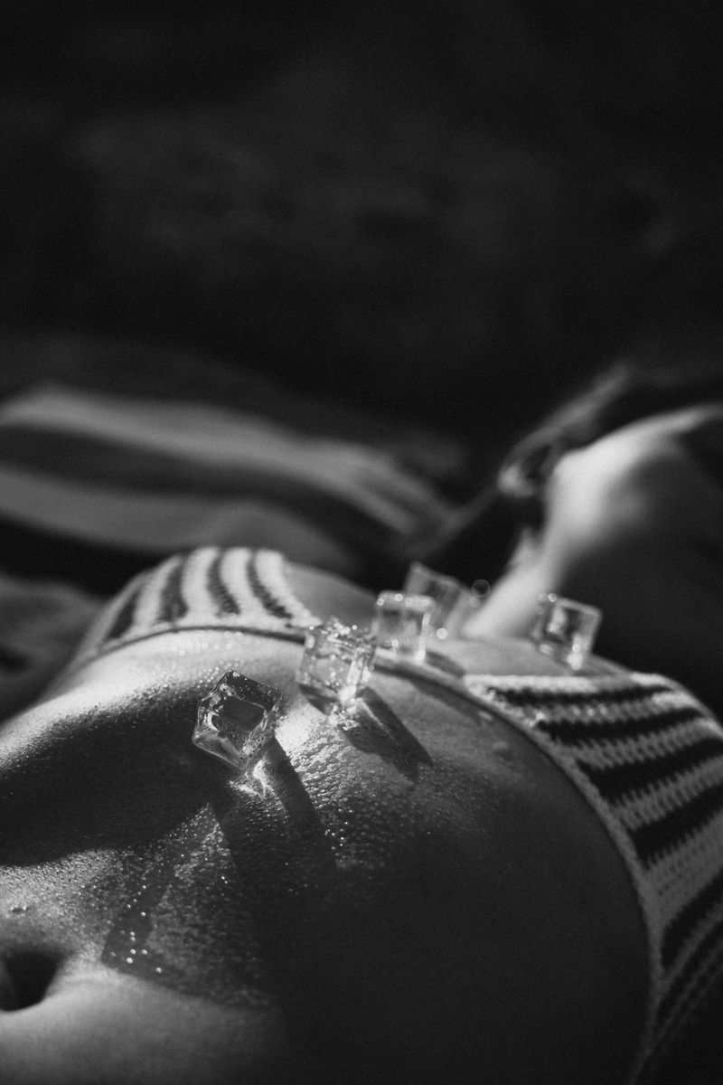 prise de vue en noir et blanc d une femme avec des cubes de glace sur le corps mettant en avant la mode et l art
