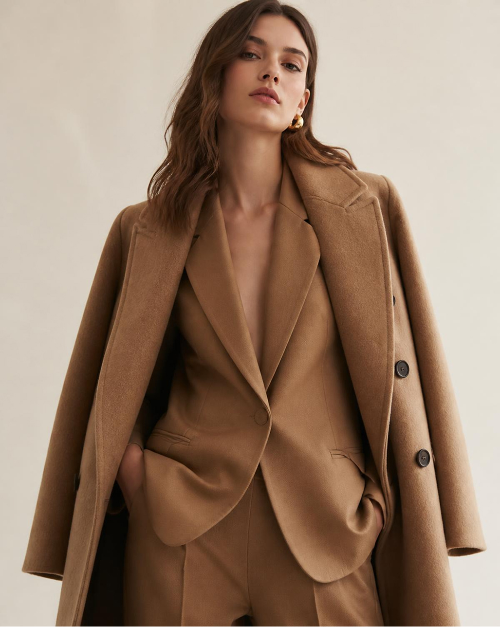 femme portant un manteau et un blazer camel