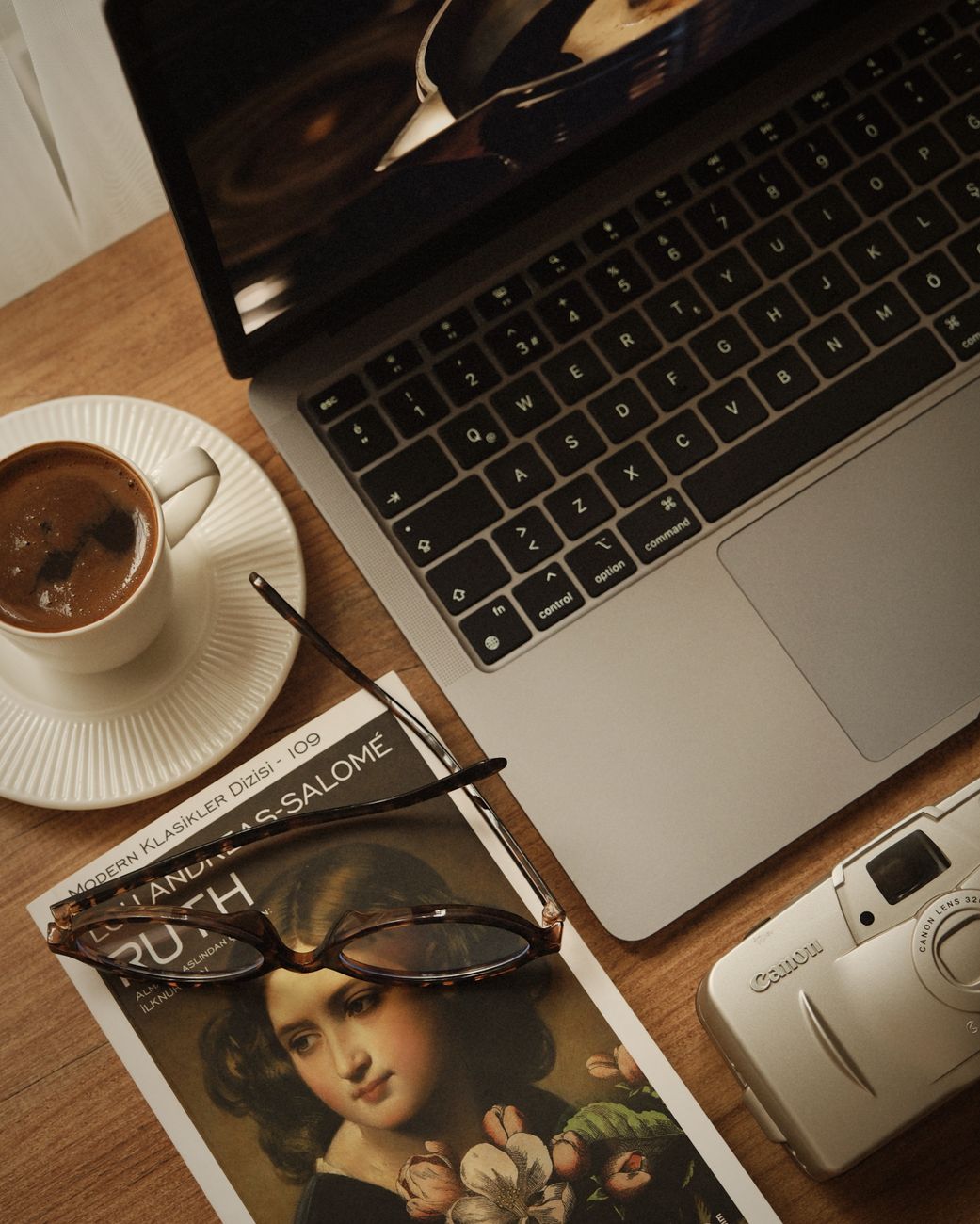 un coin detente avec un cafe un livre et un ordinateur portable sur une table en bois