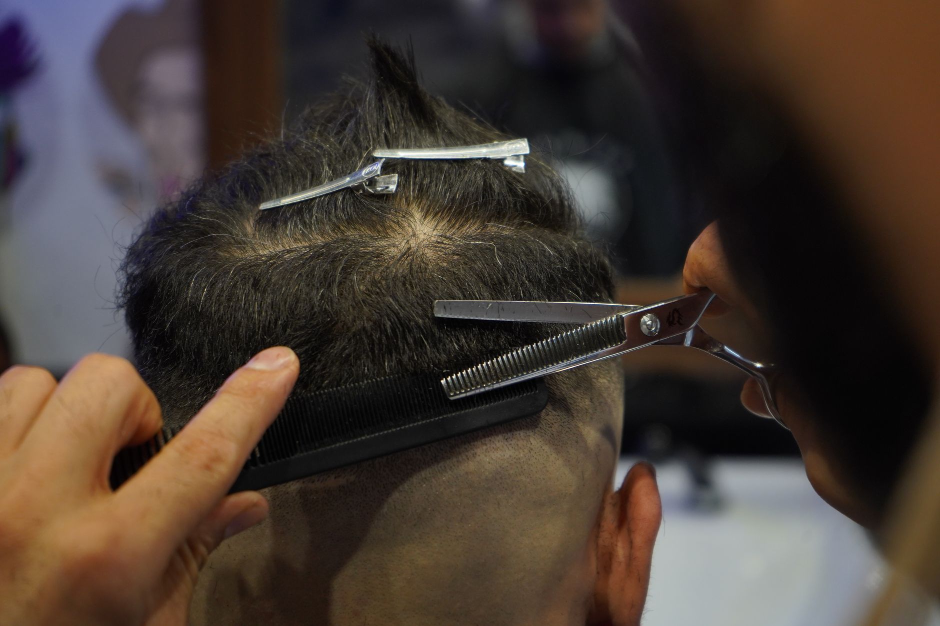 gros plan sur un barbier coupant habilement les cheveux d un client avec des ciseaux et un peigne a l interieur