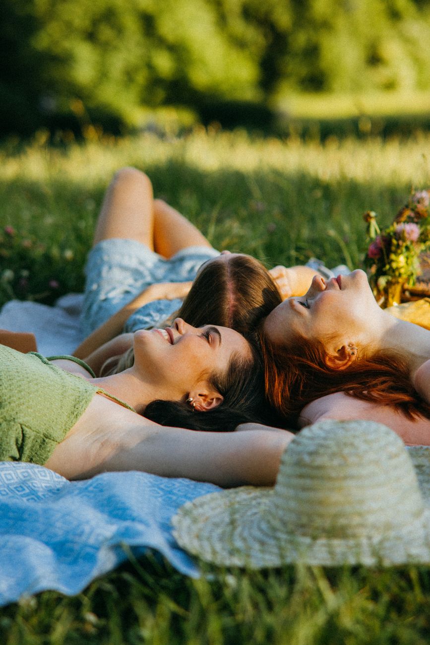 trois femmes profitant d une journee ensoleillee sur une couverture de pique nique dans le parc celebrant la convivialite et la nature