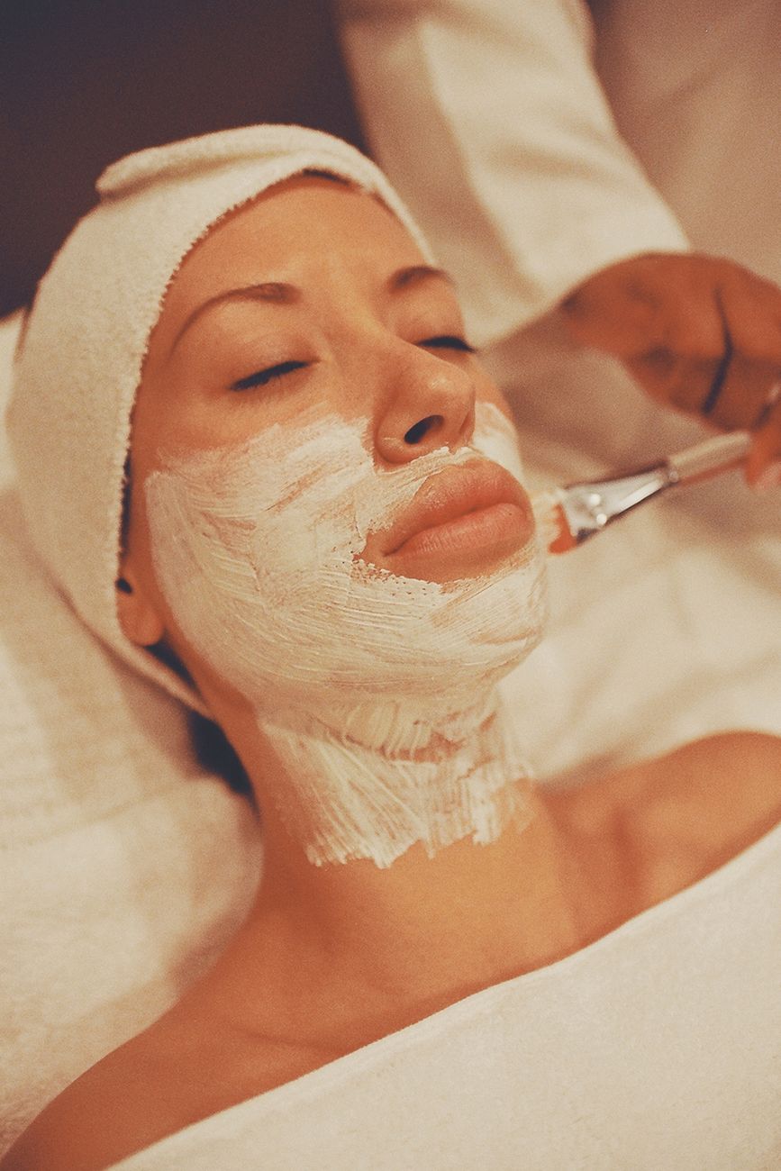 gros plan sur une femme recevant un masque facial apaisant dans un spa favorisant la detente et les soins de la peau