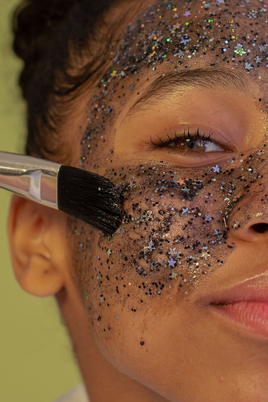 jeune femme appliquant un masque facial rajeunissant en paillettes avec un pinceau a l interieur