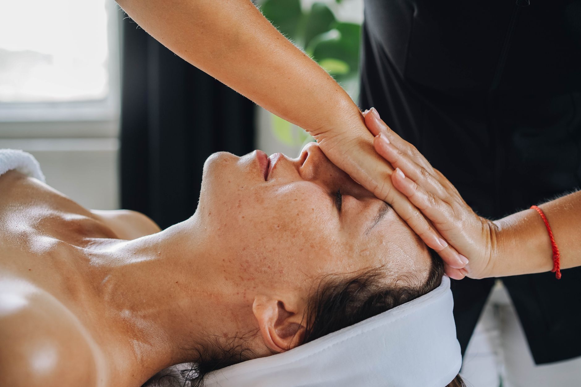 femme recevant un massage facial apaisant dans un environnement de spa paisible
