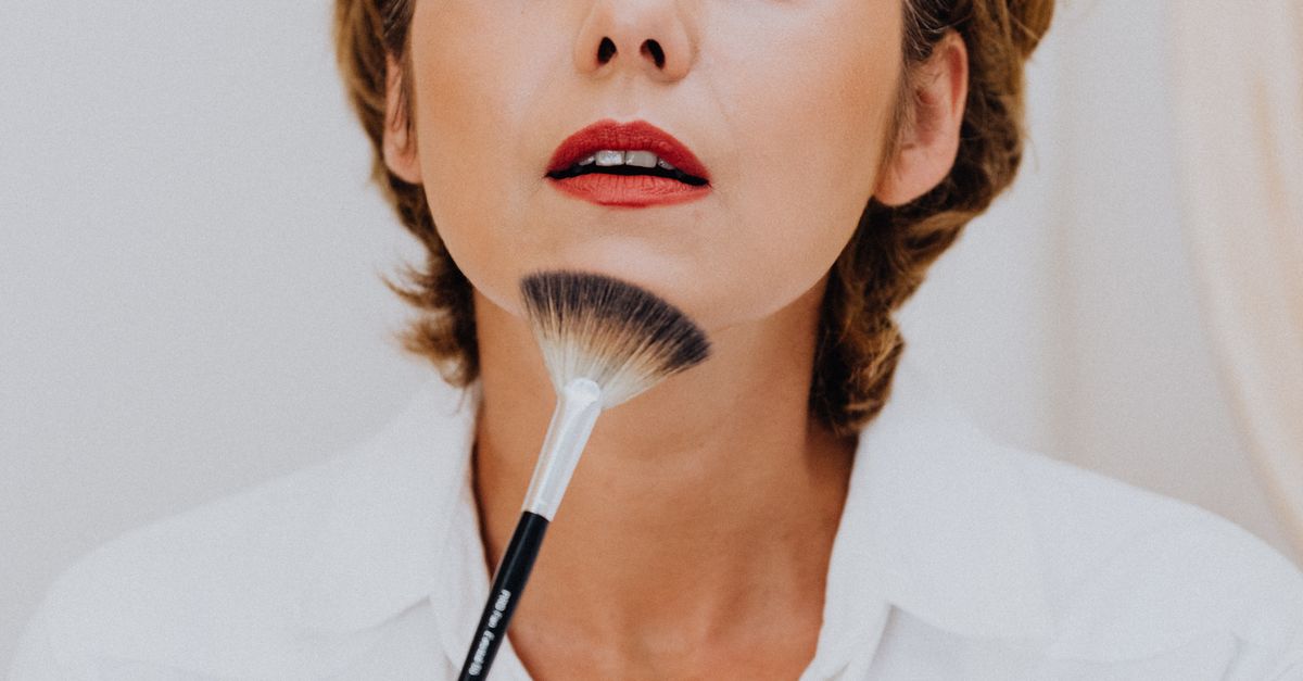gros plan d une femme appliquant du maquillage avec elegance a l aide d un pinceau avec precision